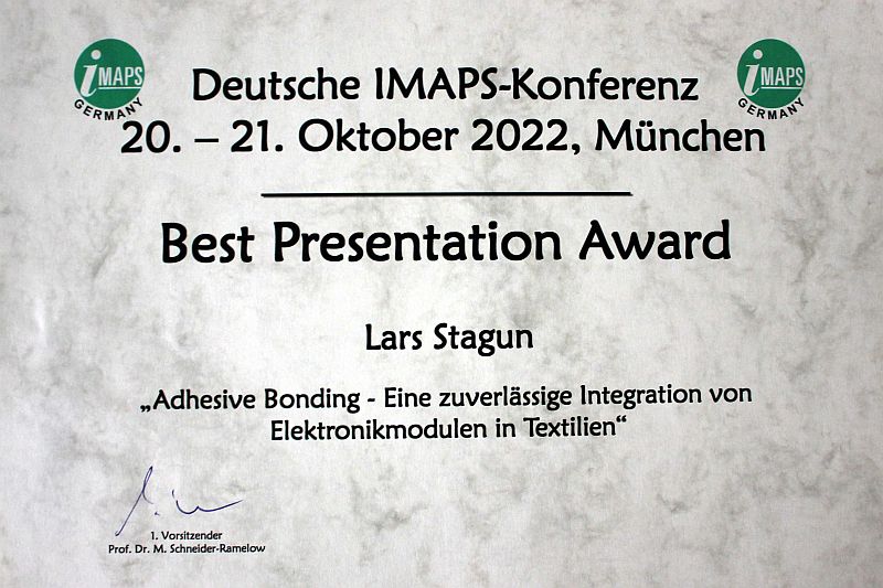 Image - Best Presentation Award bei der IMAPS 2022, Urkunde wird überreicht an Lars Stagun von Prof. Martin Schneider-Ramelow