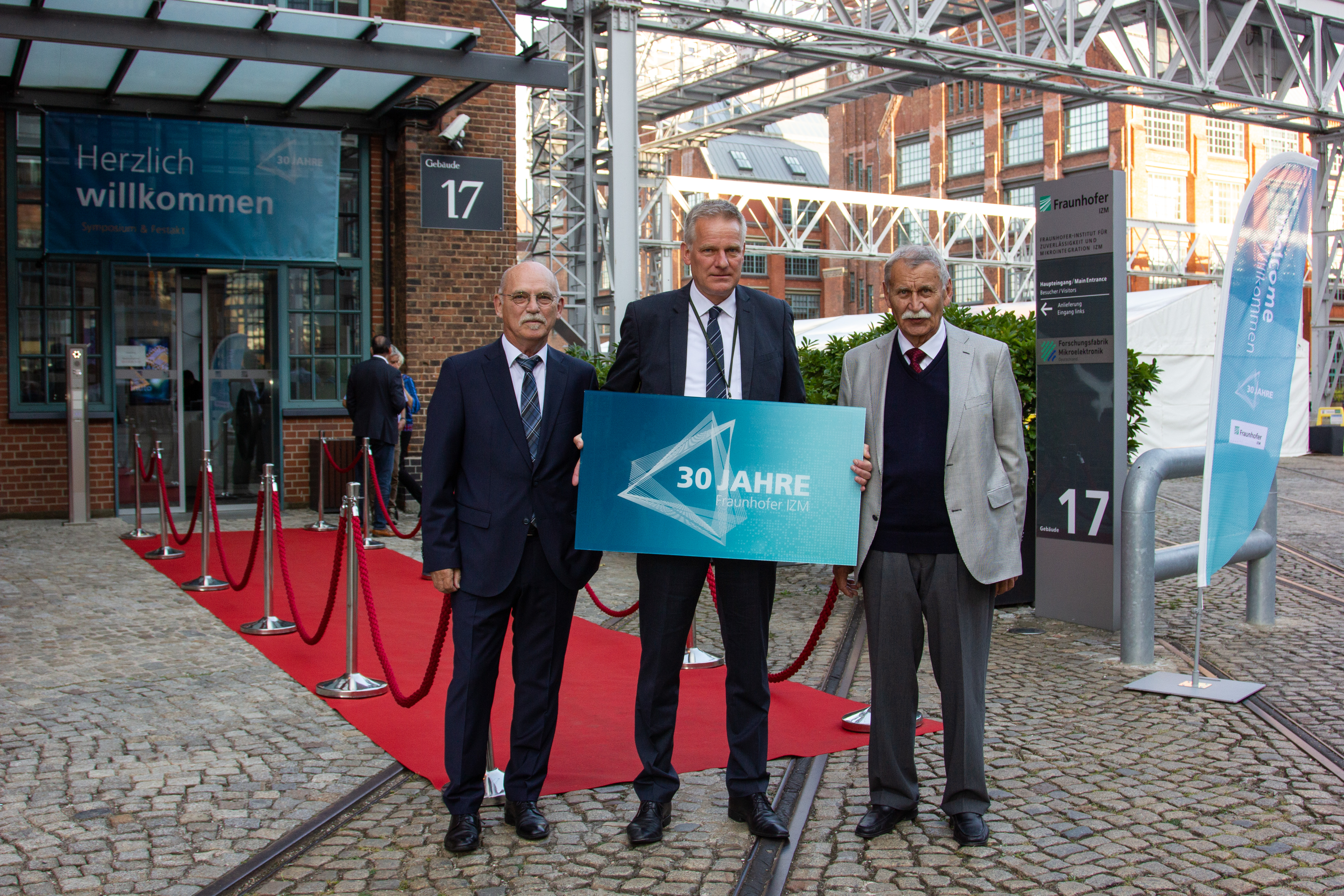 Institutsleiter Prof. Martin Schneider-Ramelow (mit Schild) zusammen mit seinen Vorgängern, Prof. Klaus-Dieter Lang (links) und Prof. Herbert Reichl